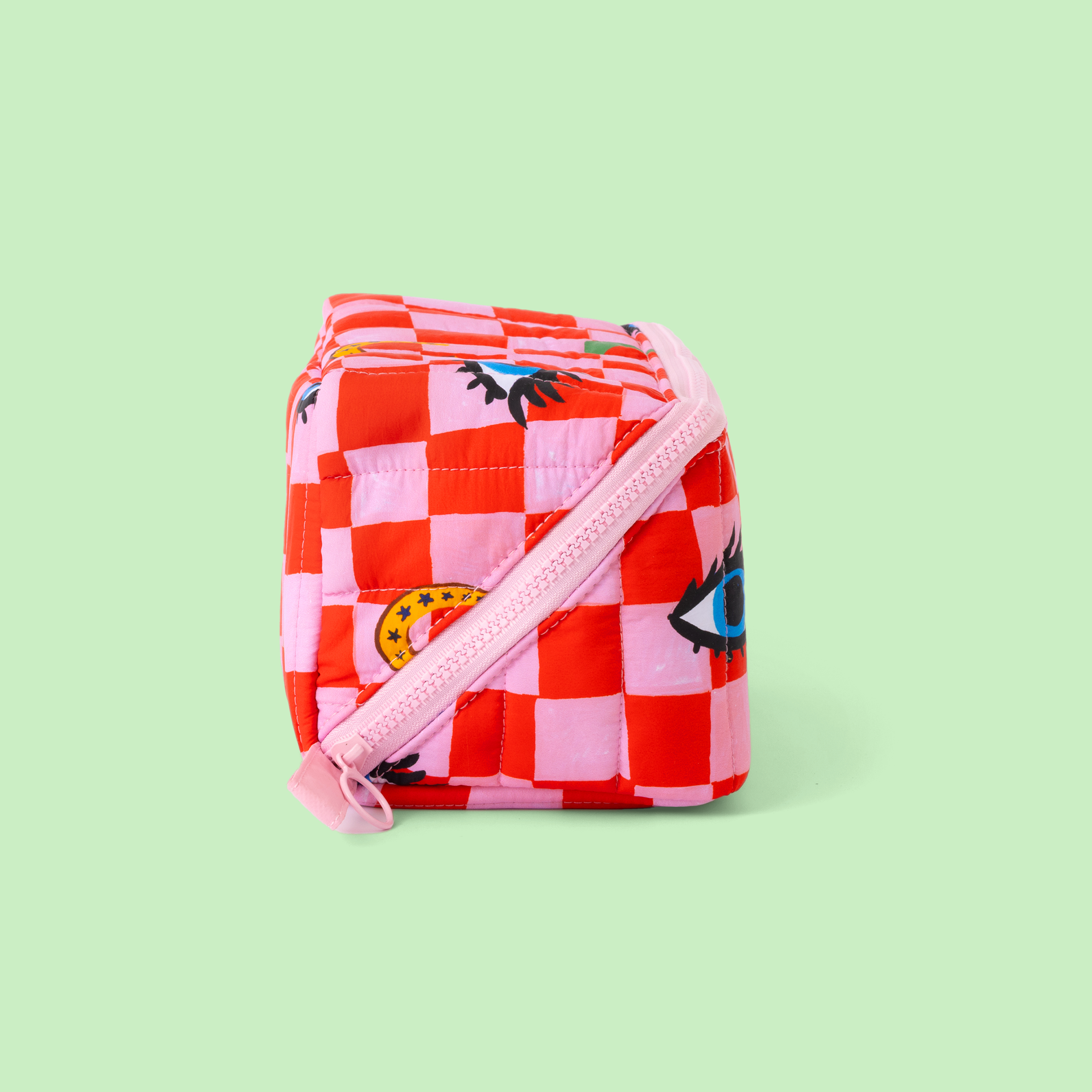 Red and pink checkered bag with a strap on a light green background