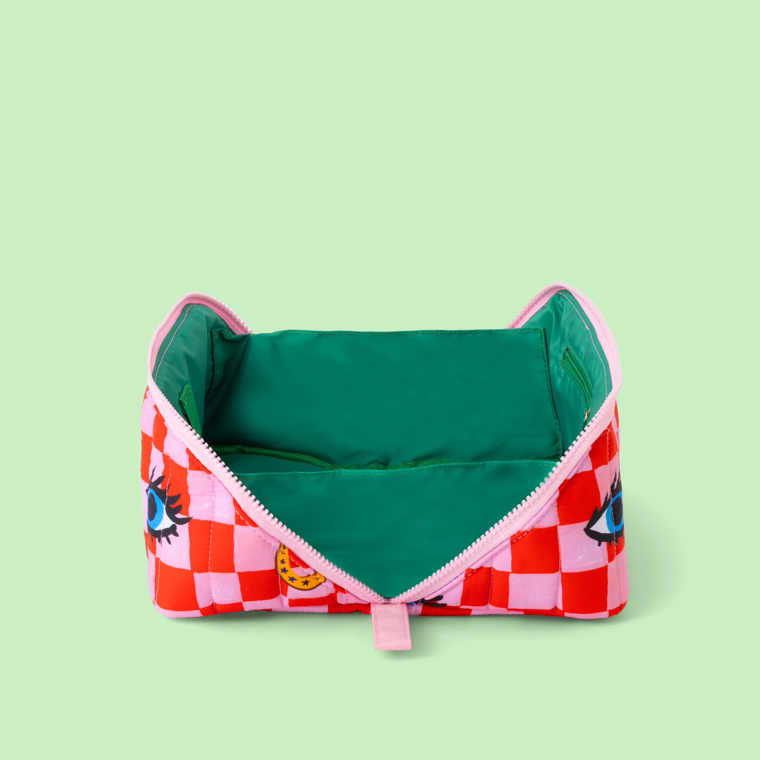 Colorful make up bag with checkered pattern and cartoon face on a light green background