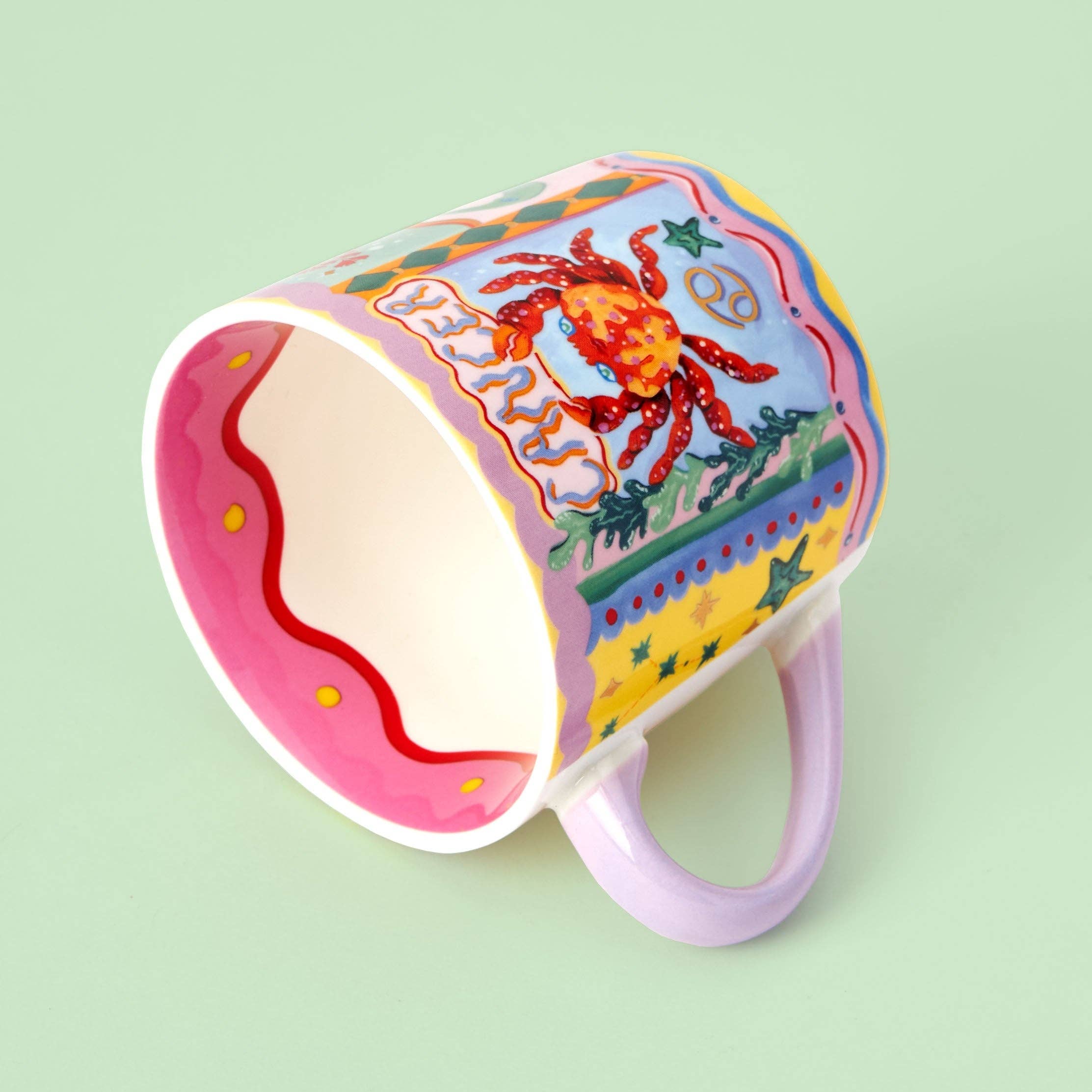 Colorful mug with a crab design on a light green background