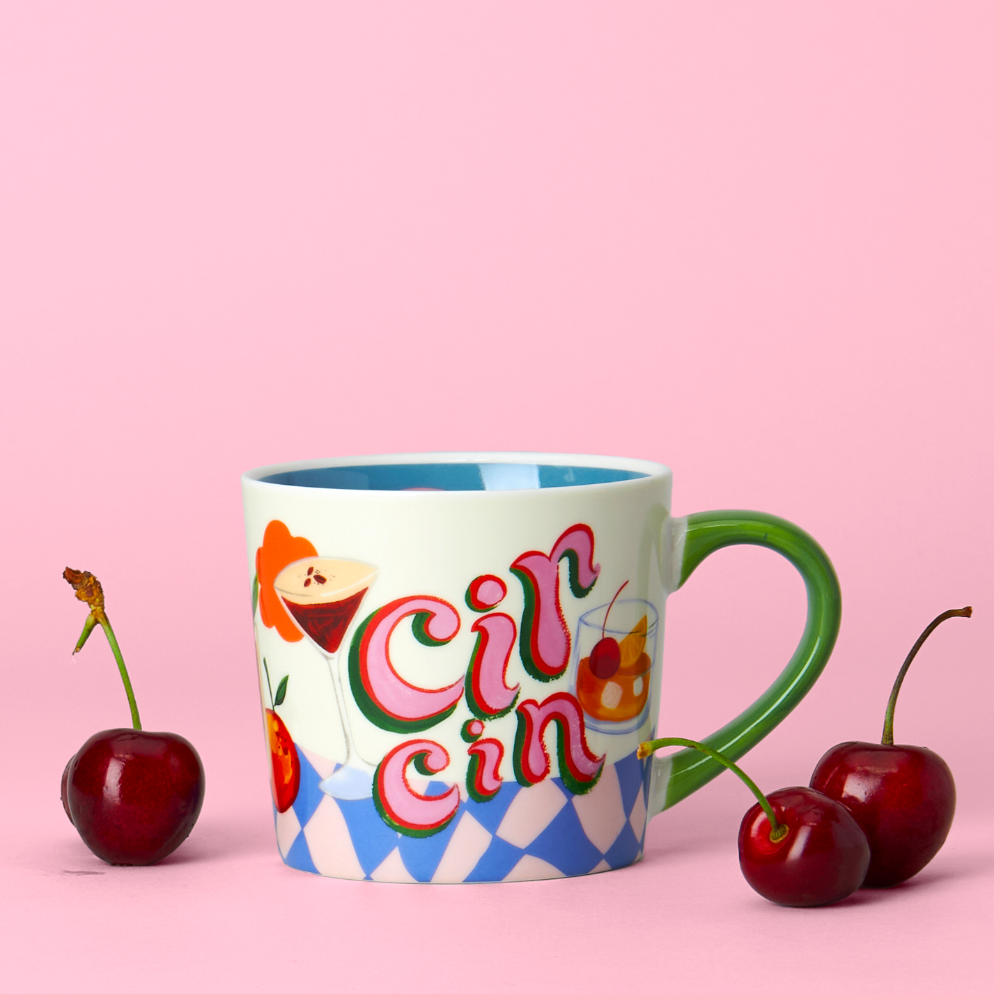 Colorful mug with 'Cin Cin' text and cherries on a pink background