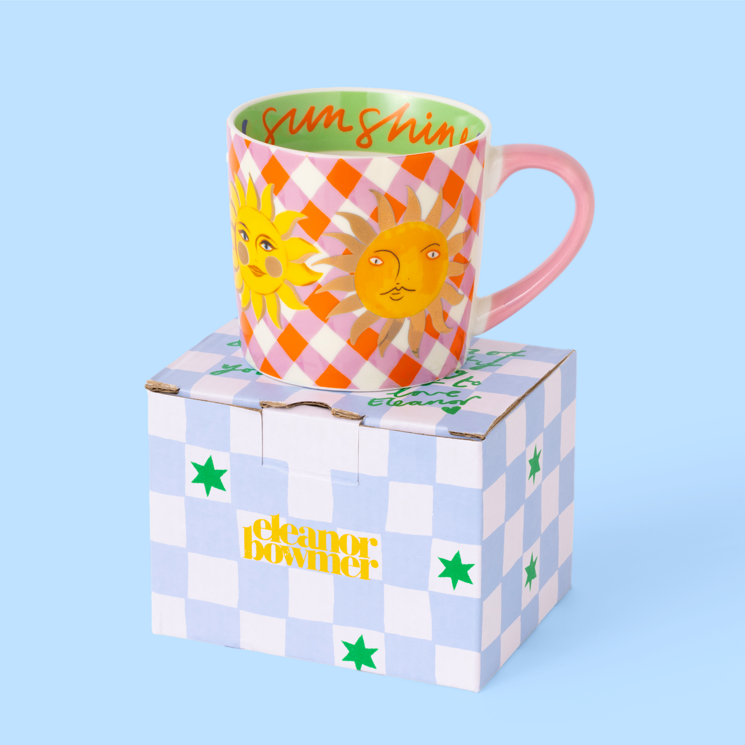 Colorful mug with sun design on a checkered box against a light blue background