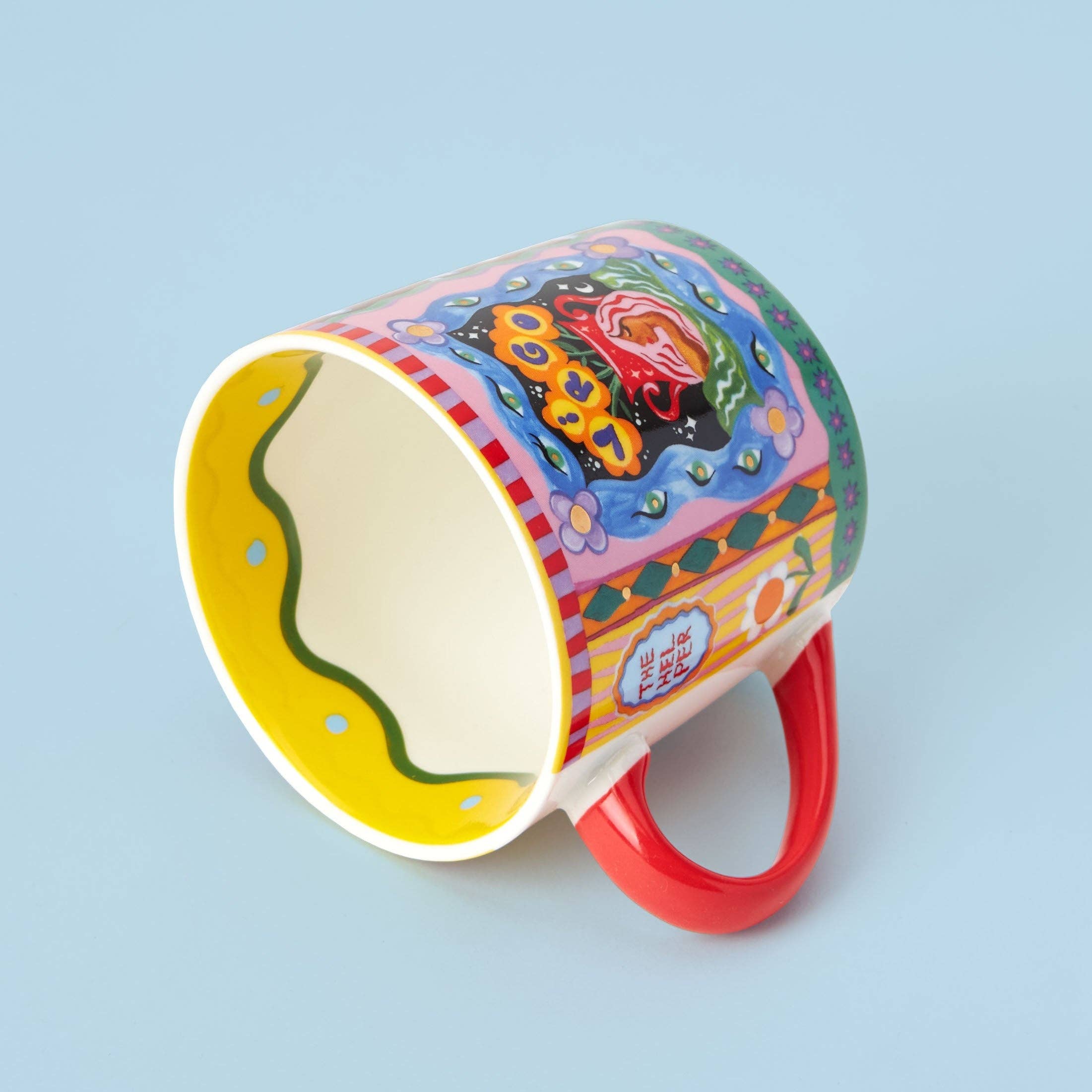 Colorful mug with a red handle on a light blue background