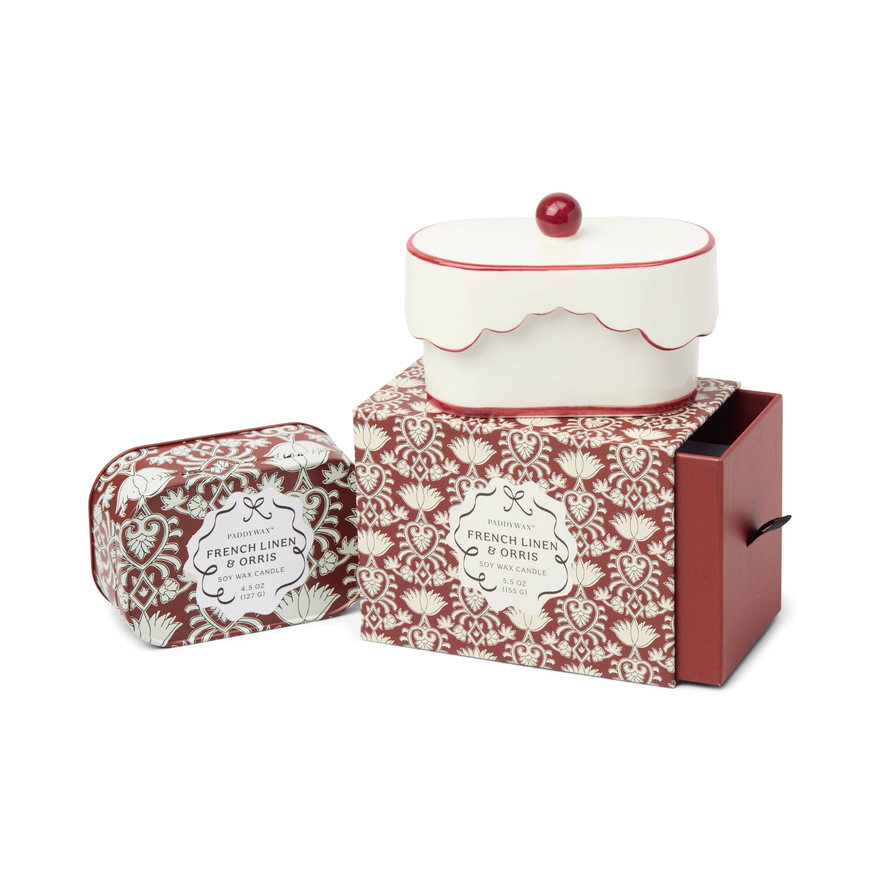 Decorative ceramic cake-shaped container with a red lid on a white background