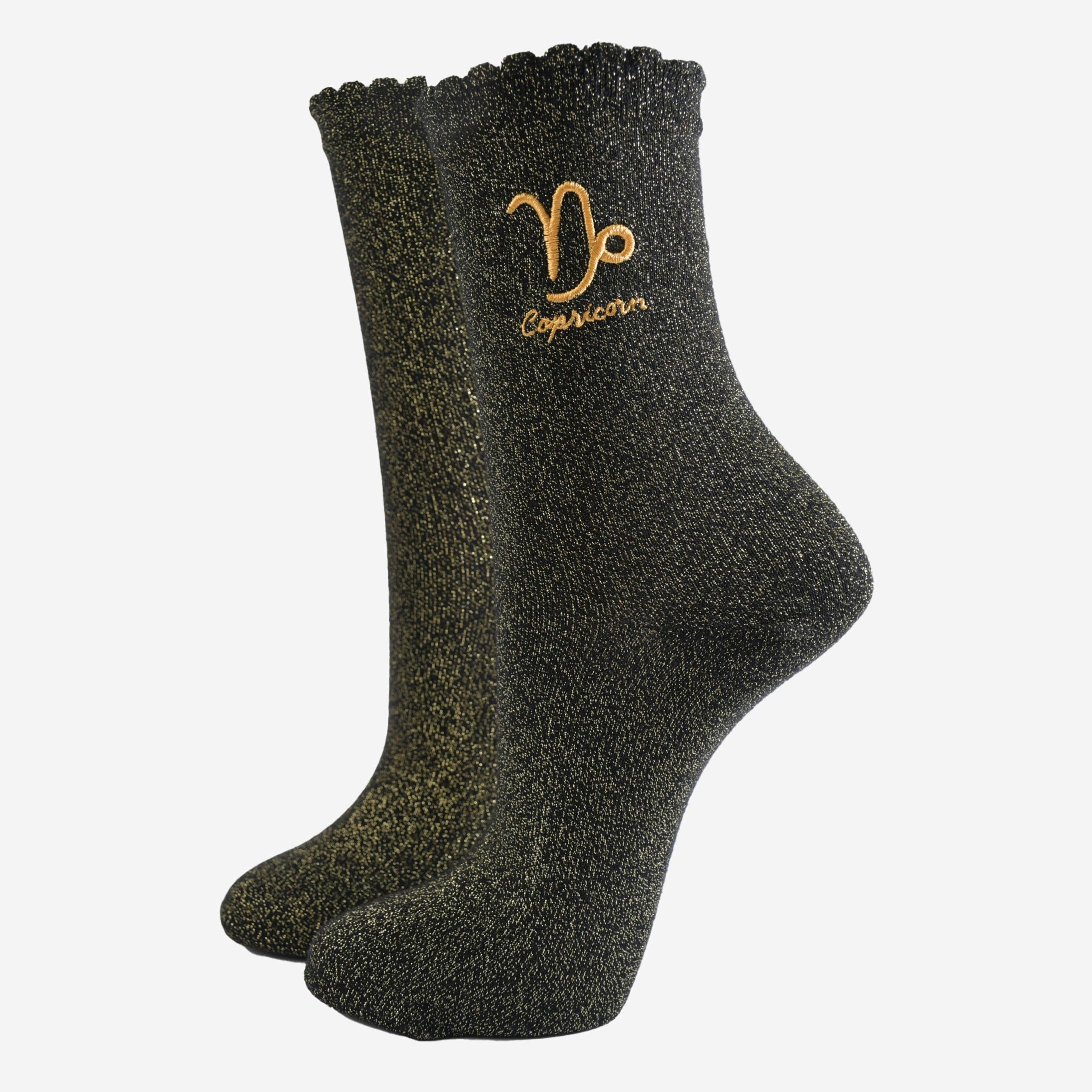 Black glittery socks with Capricorn symbol on a white background