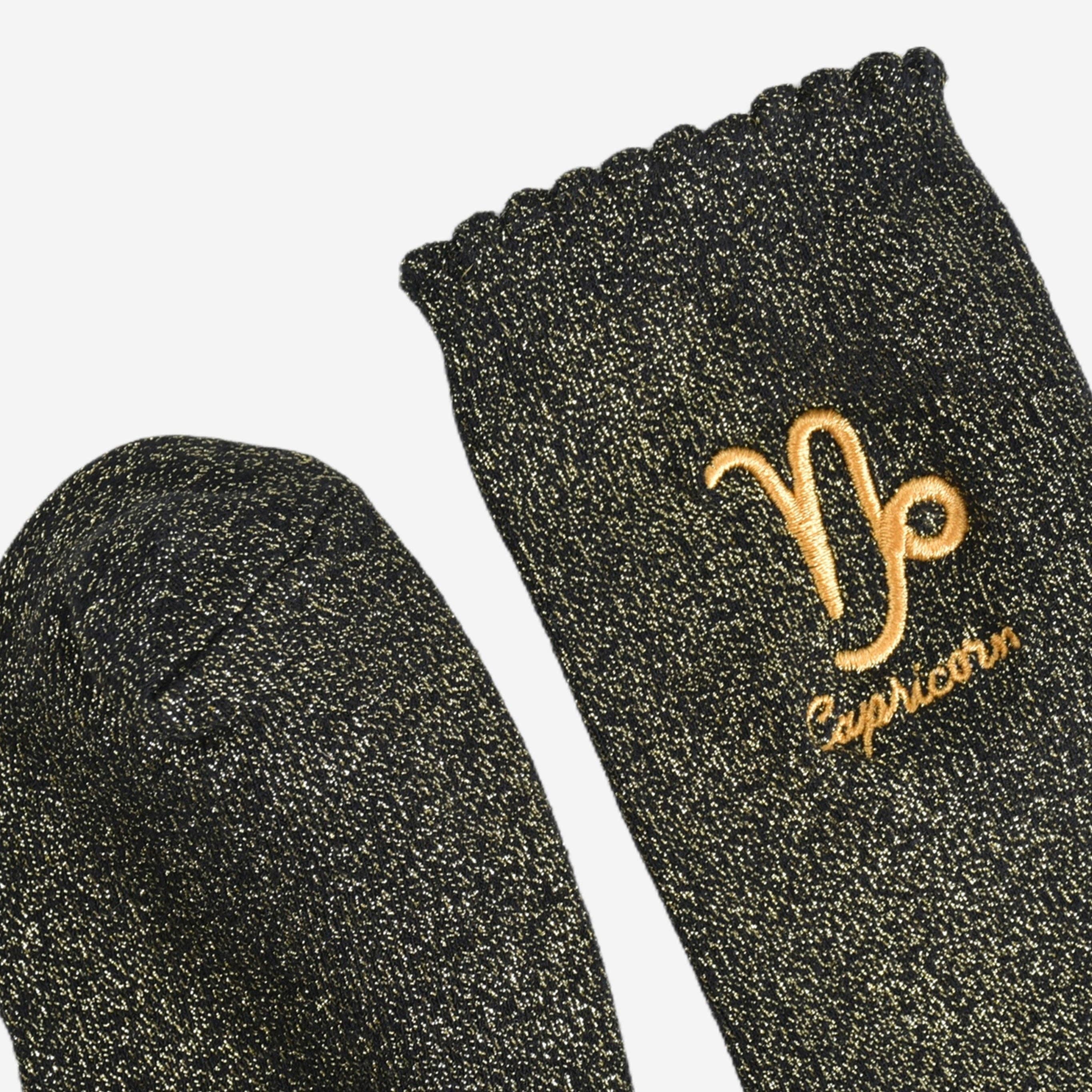 Black socks with gold Aries symbol and 'Aries' text on a white background
