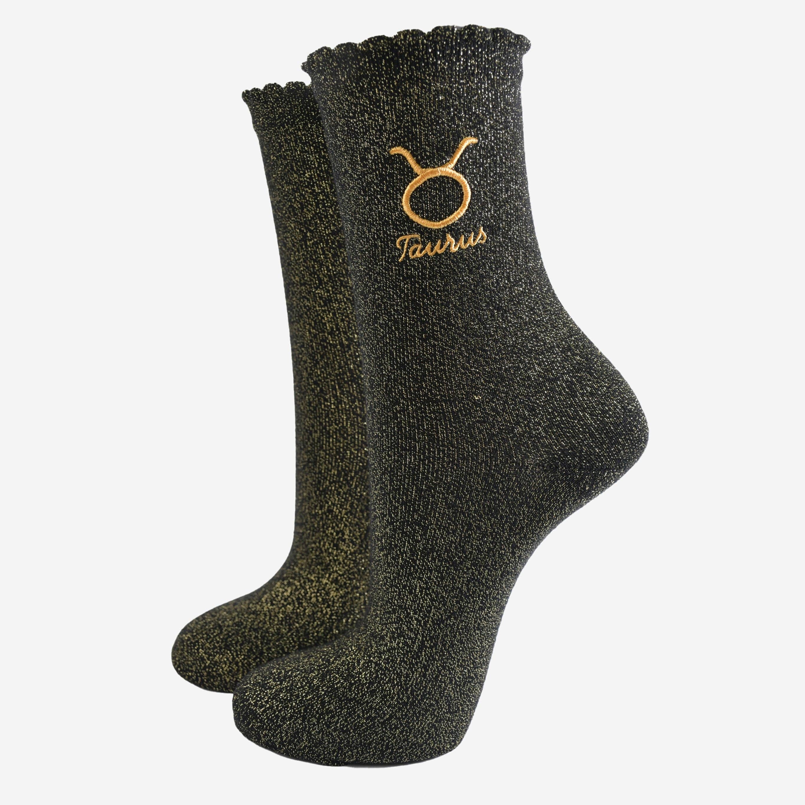 Black socks with Taurus zodiac sign embroidery on a white background