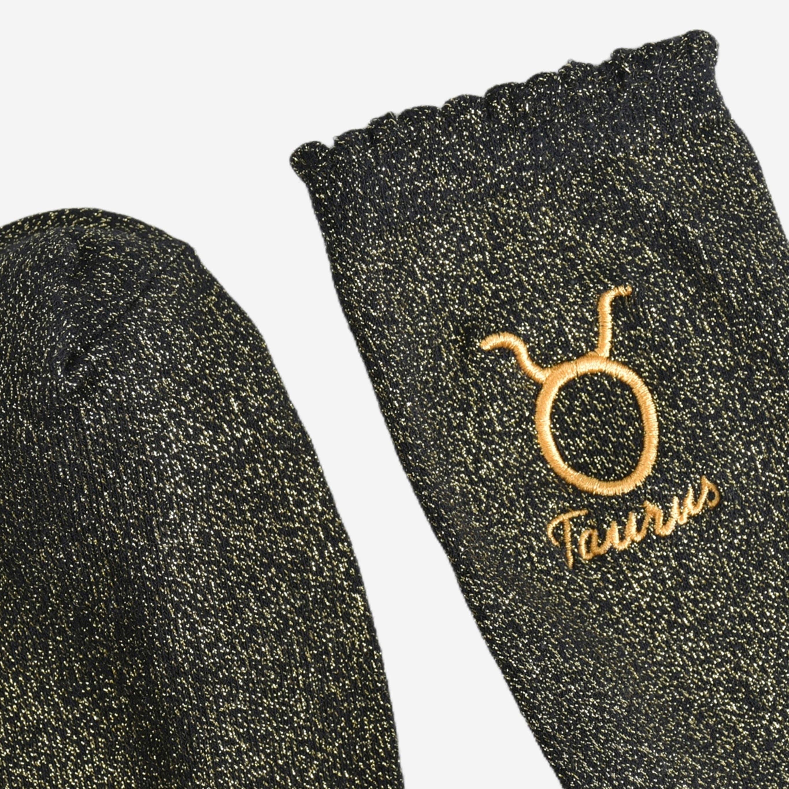 Black socks with gold embroidery on a white background