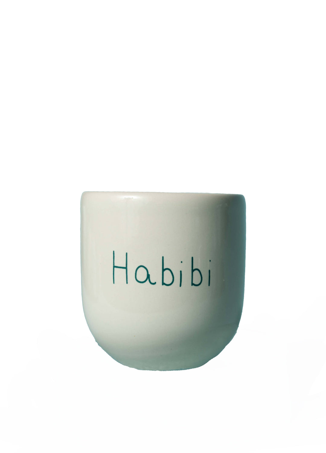 A small white ceramic cup with the word 'Habibi' printed in a teal handwritten font on the front, set against a plain white background.