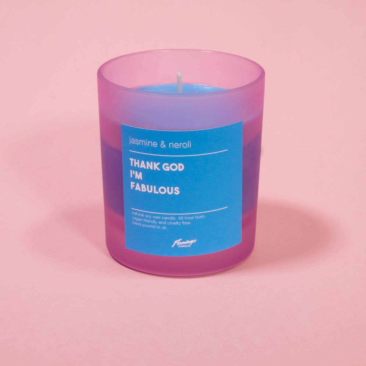 Candle with a blue label on a pink background