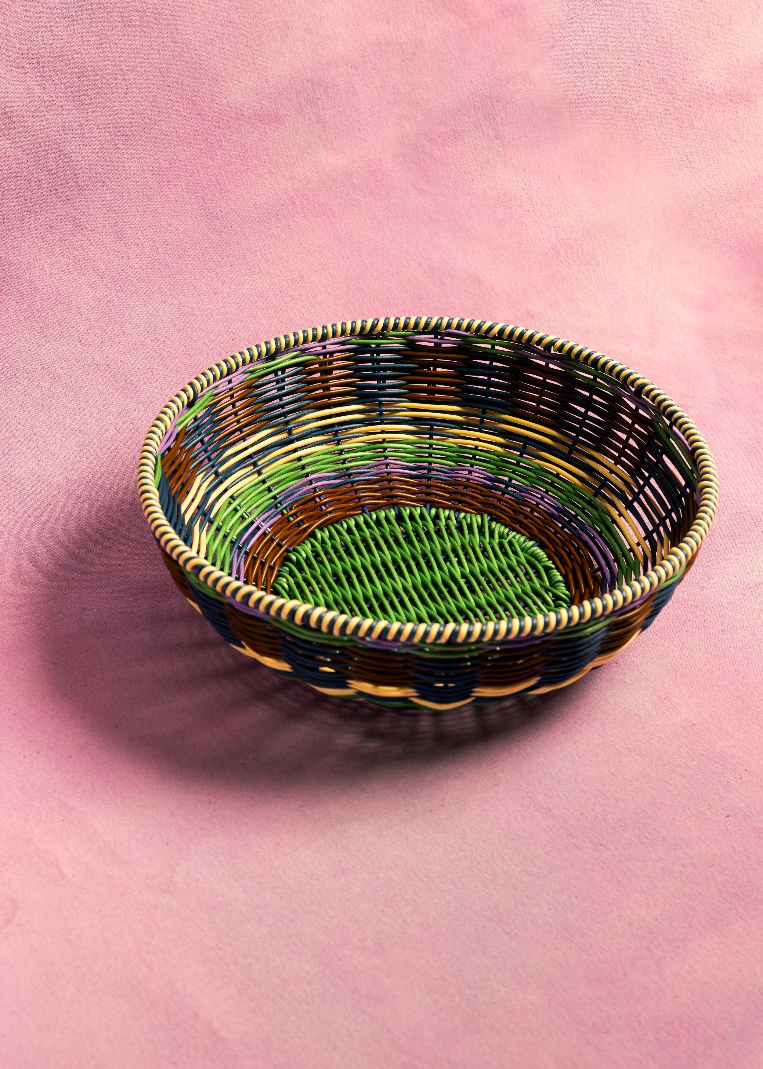 Woven basket with multicolored pattern on a pink background