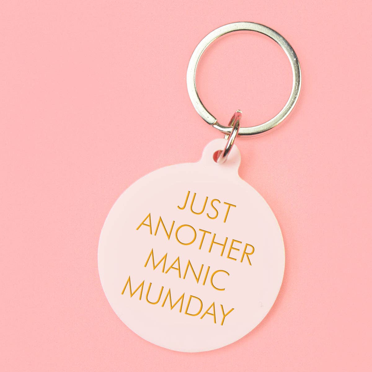 Keychain with 'Just Another Manic Munday' text on a pink background