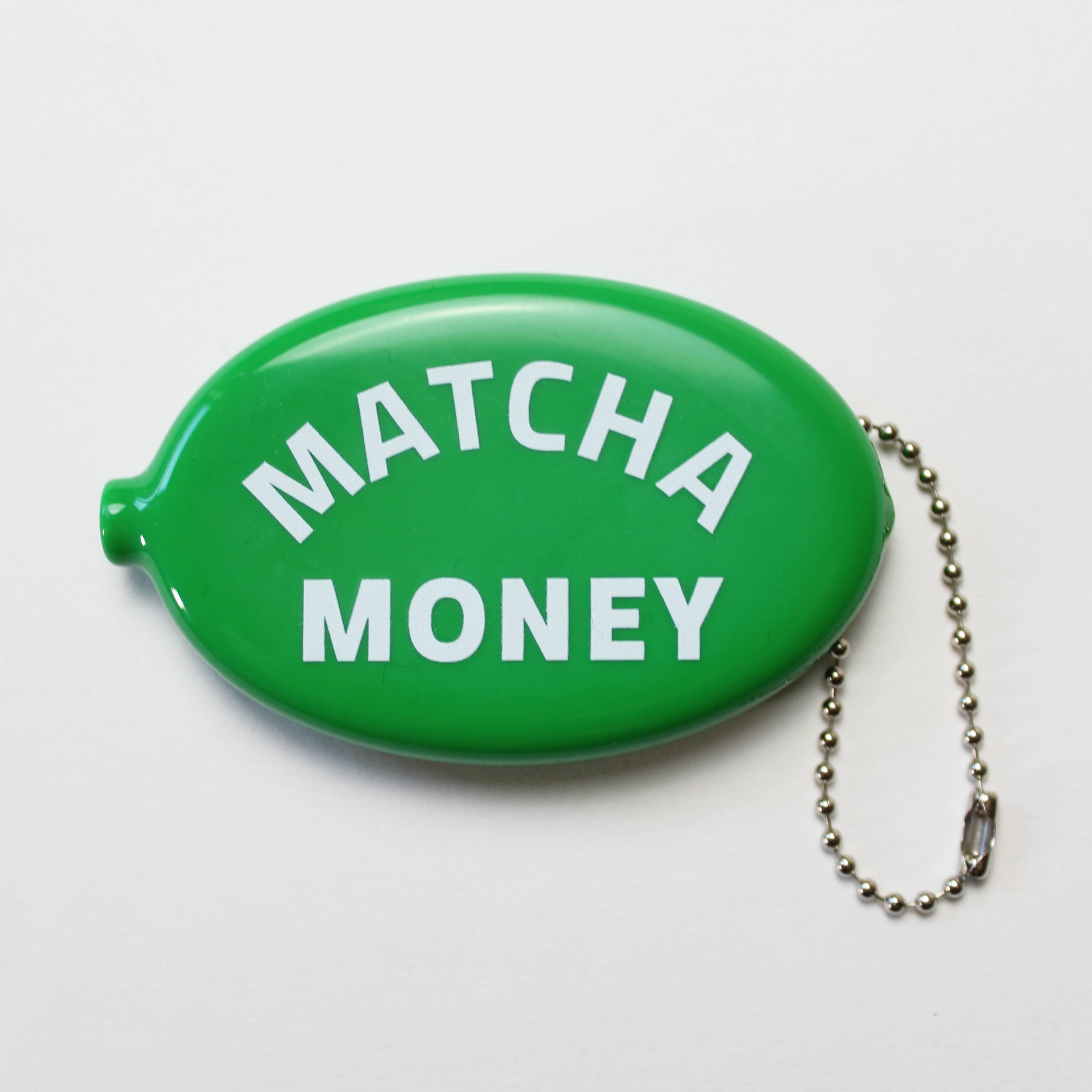 Green oval container with 'Matcha Money' text and a chain on a white background