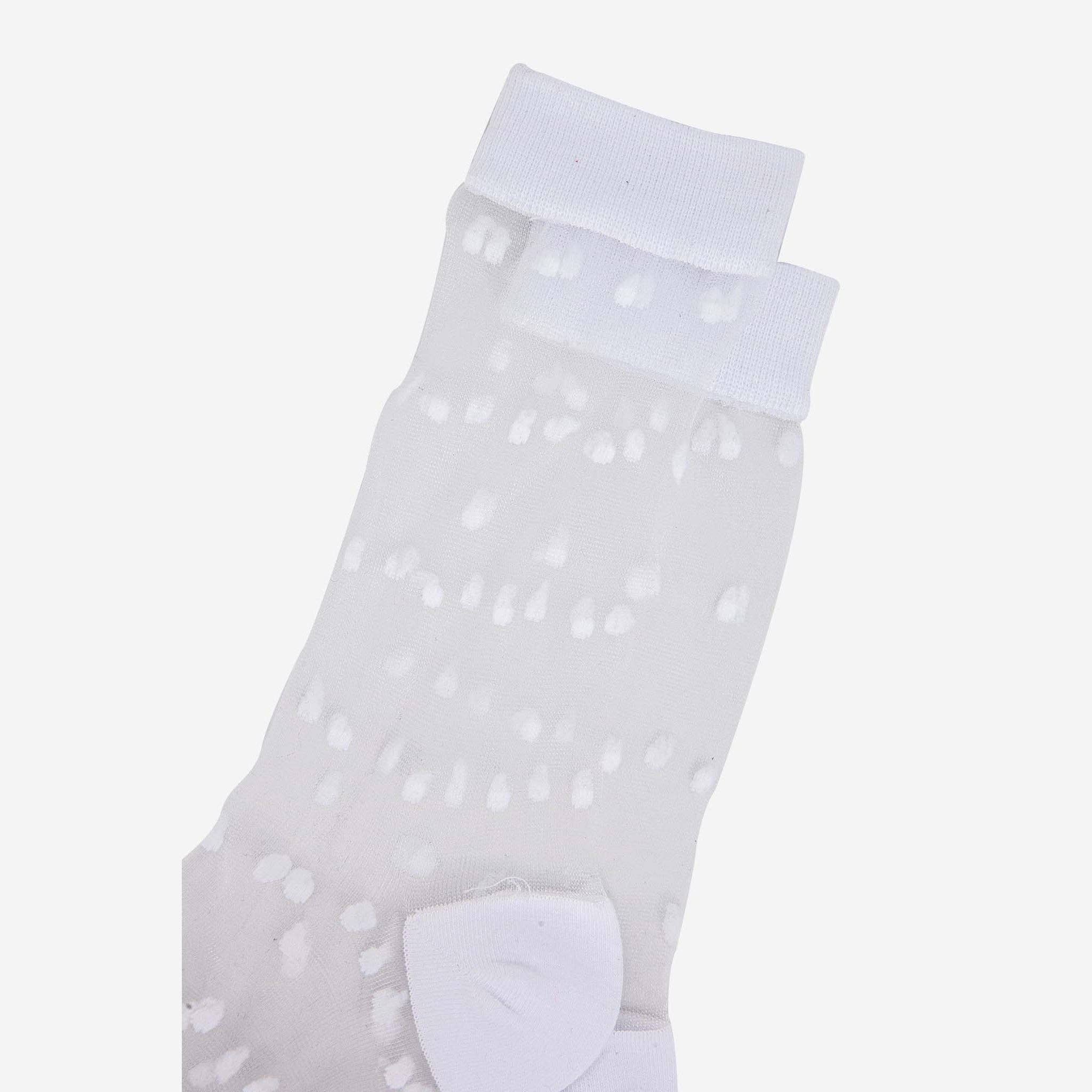 White ankle sock with polka dot pattern on a light gray background