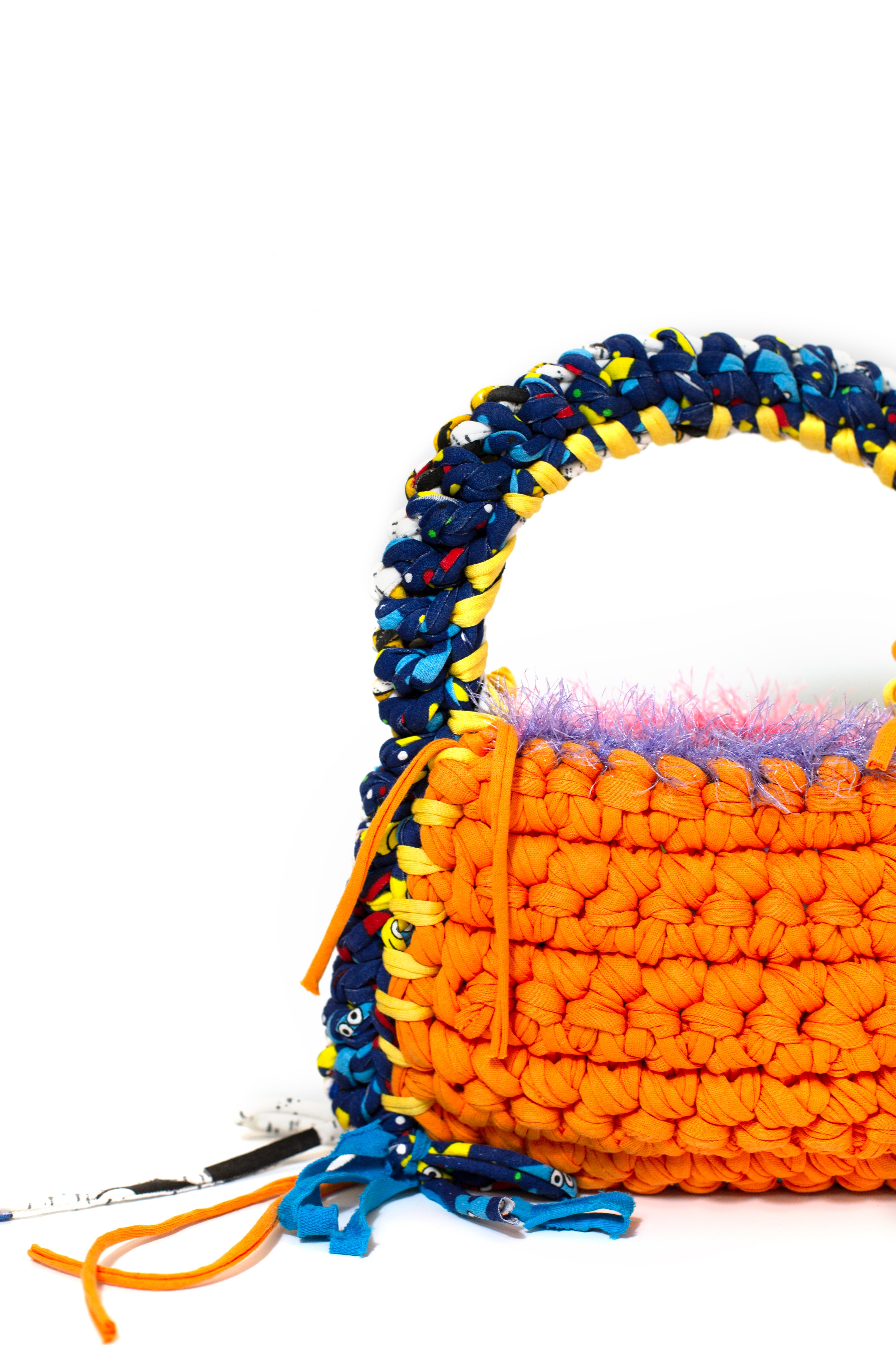 an orange, yellow and multicolour crochet shoulder bag on a white backdrop