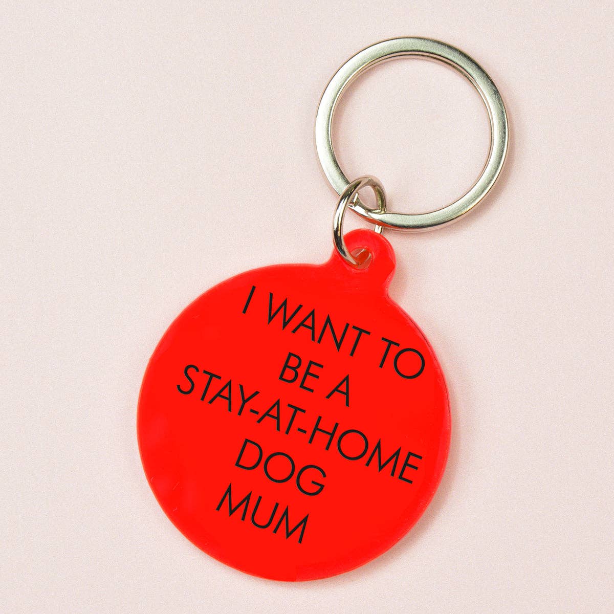 Red keychain with text reading "I want to be a stay at home dog mum" on a light pink background