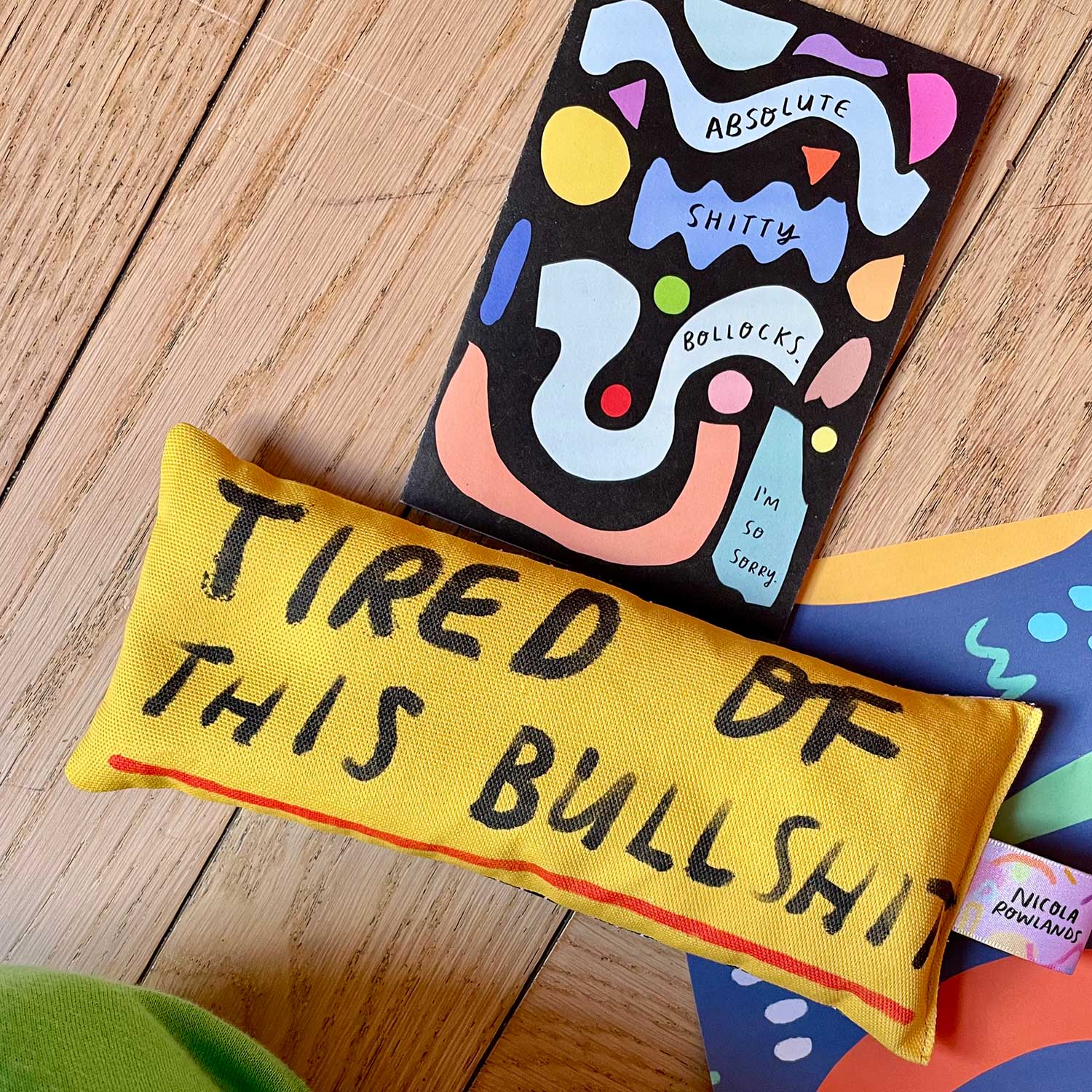 Colorful pillows with text on a wooden surface